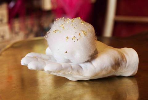 A plaster hand holds a cotton candy at Ã© by JosÃ© AndrÃ©s