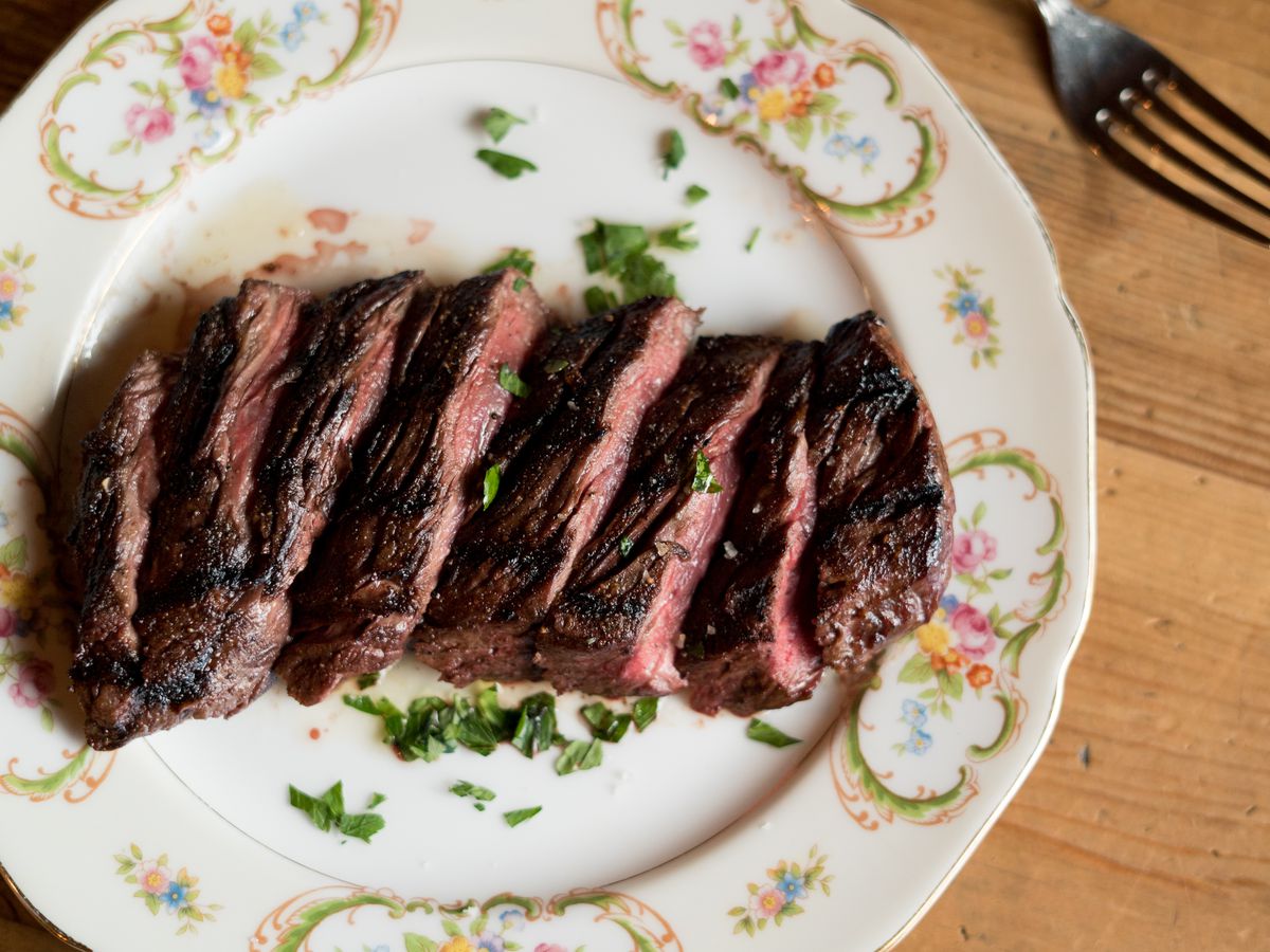 Delight in the sight of an exquisitely prepared medium-rare steak adorned with vibrant green onions.
