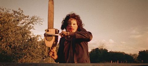leatherface holds up a chainsaw in a scene from the texas chainsaw massacre, a good housekeeping pick for best halloween movies
