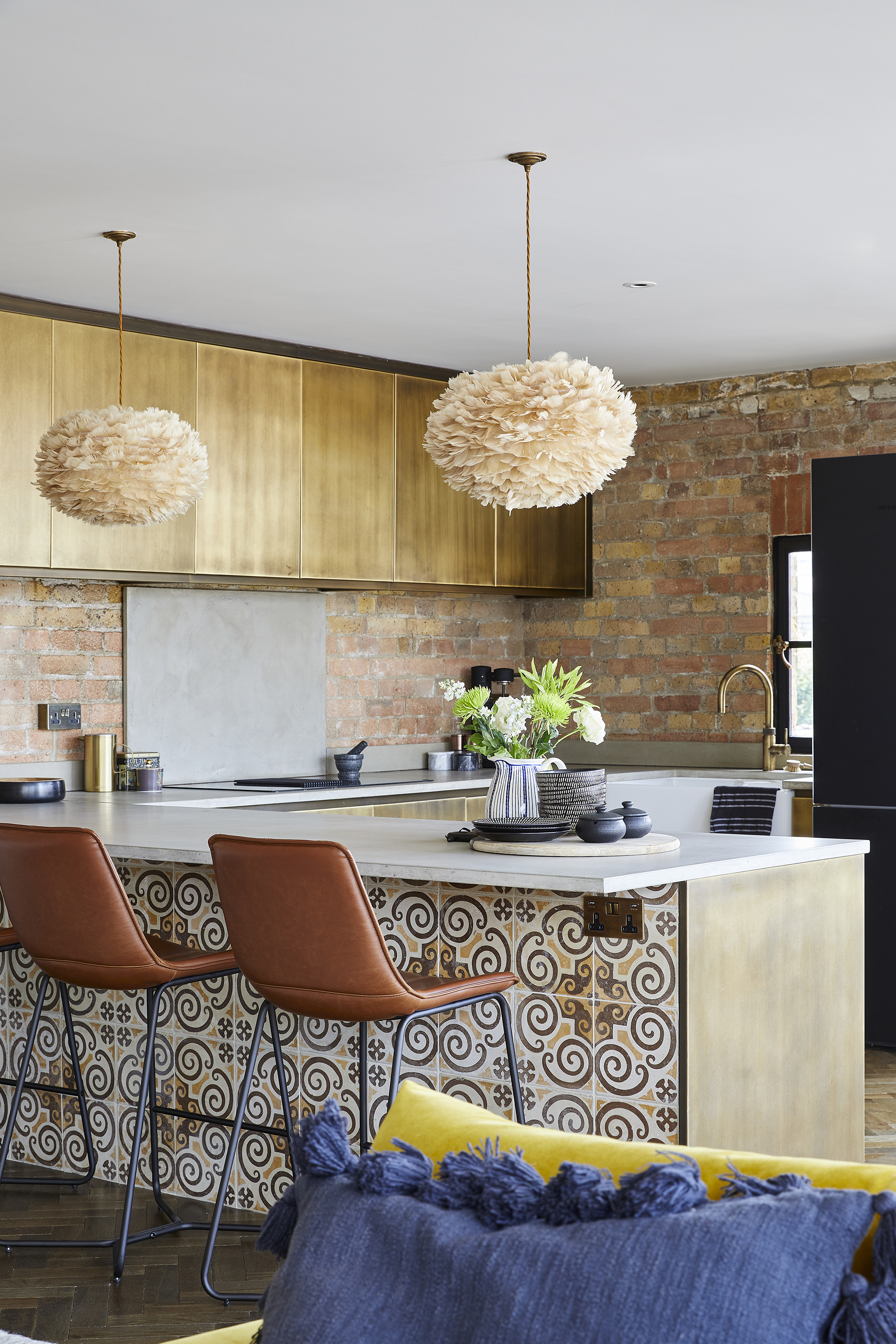small kitchen with tiled peninsula and leather bar stools