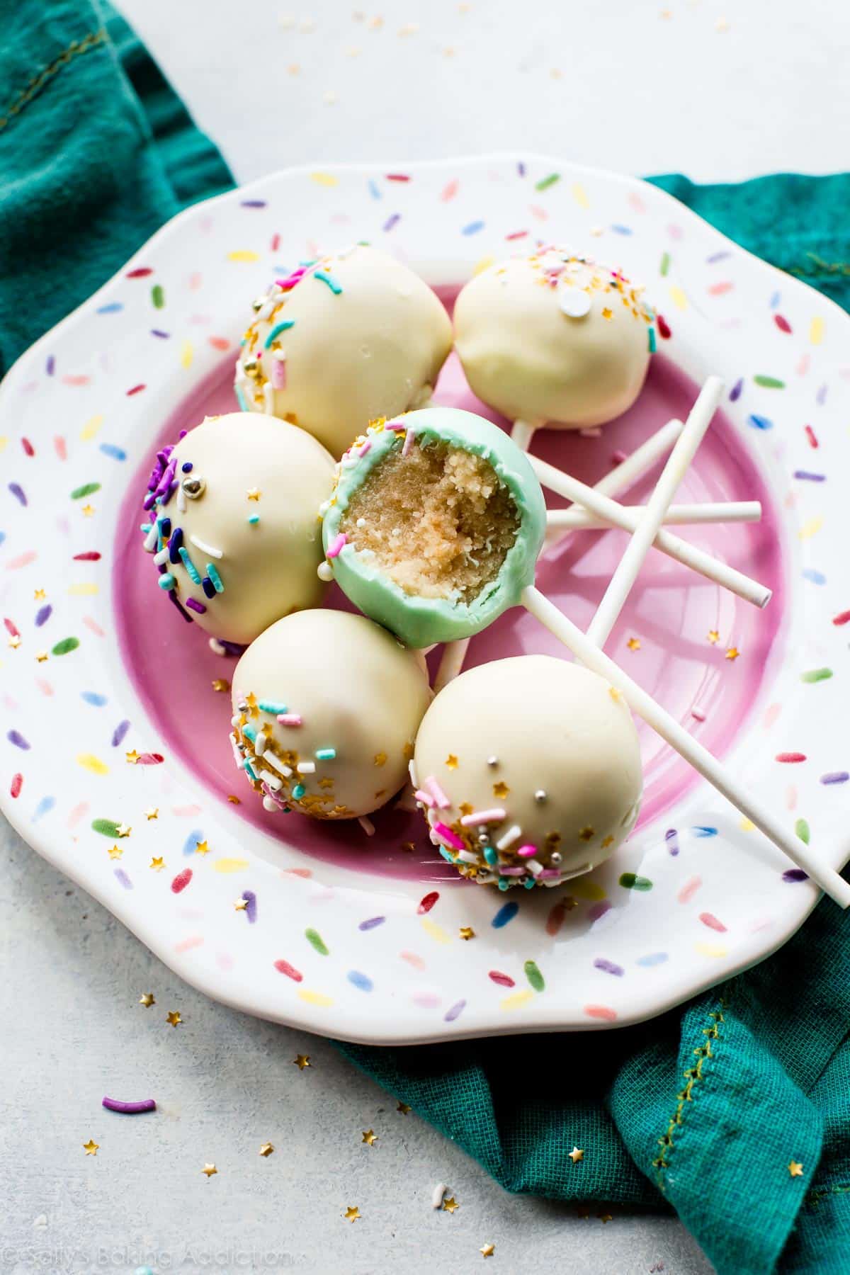 vanilla cake pops on a sprinkle plate